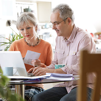 couple with paperwork at computer