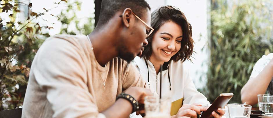 friends smiling and looking at phone