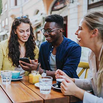 Friends at table looking at phone