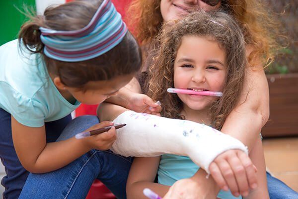 little girls painting her mother's plaster arm